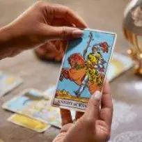 Vrouwenhand met de tarotkaart "Ridder van Staven"
